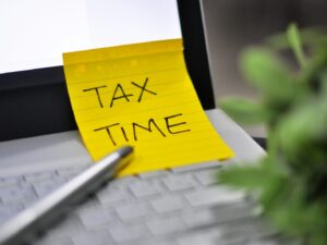 Yellow sticky note with tax time written on it.