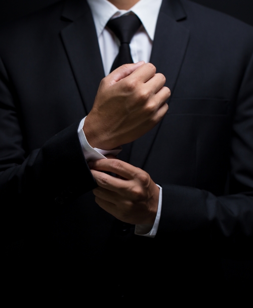Man wearing suit adjusting his shirt cuff